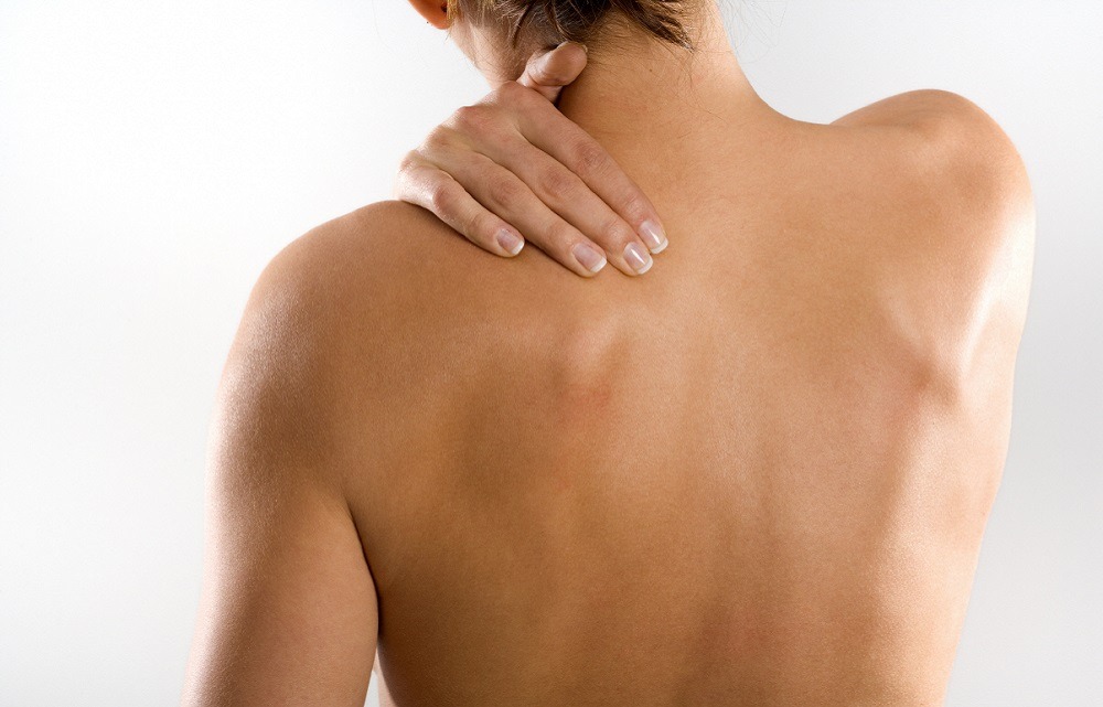 Lady in pain holding shoulder